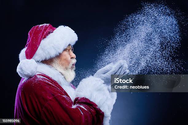 Santa Claus Blowing A Handful Of Snow Stock Photo - Download Image Now - Santa Claus, Blue, Blowing