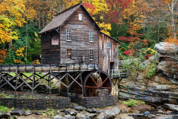 wooden water mill situated on the banks of a tranquil river in babcock state park, west virginia. - babcock state park imagens e fotografias de stock