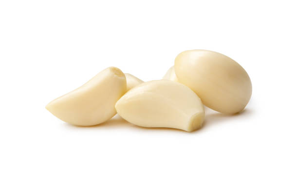 istock Peeled garlic cloves in stack isolated on white background with clipping path. 1559976393