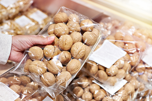Buyer with walnuts in shell at store