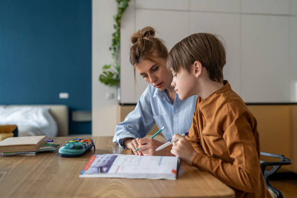 istock Schoolboy having lesson with private teacher at home 1559979146