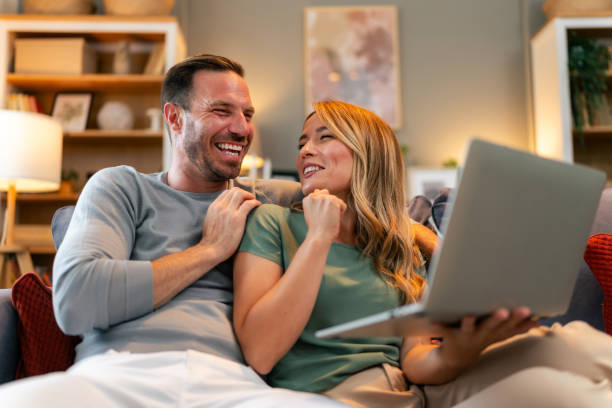 istock Happy couple with laptop spending time together at home. 1559982624