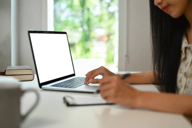 istock Side view of female freelancer working online on laptop and writing important notes. 1560000187