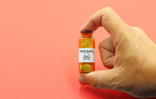 mano mostrando un frasco de pastillas de fentanilo, un potente opioide que puede causar la muerte por sobredosis. - morfina medicamento fotos fotografías e imágenes de stock