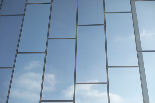 Mirror wall. Texture of building. Reflection of sky in mirrors. Details of modern architecture.