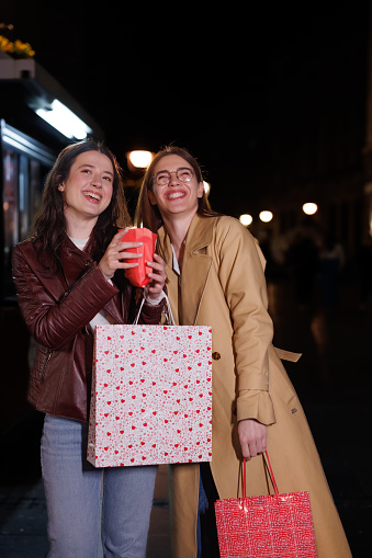 Two Female Friends Revel in Popcorn Pleasures During Their City Night Stroll