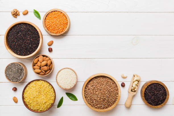 various superfoods in smal bowl on colored background. superfood as rice, chia, quinoa, lentils, nuts, sesame seeds, almonds. top view copy space - quinoa sesame chia flax seed imagens e fotografias de stock