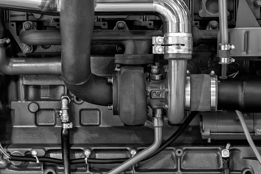 Close-up of diesel engine turbocharger, Diesel and gas industrial electric generator. Turbocharger with pipes on the engine.