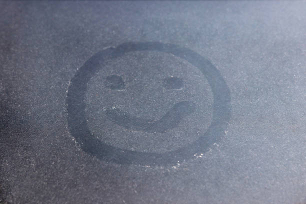 istock Smiley painted on the glass with dust. 1560056751