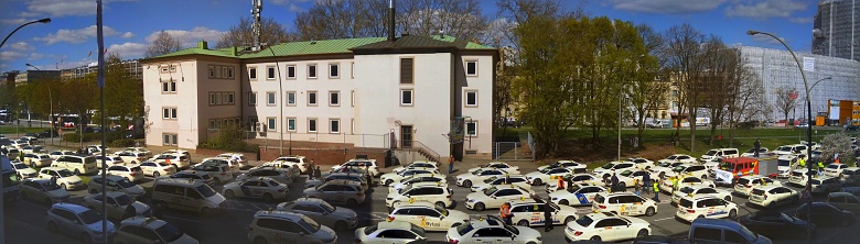 Picture of a meeting of numerous Hamburg cab drivers in the city center of Hamburg. More precisely, in the St. Georg district. In the background various commercial buildings.