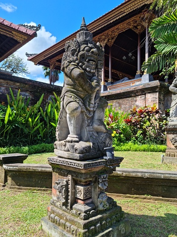 Ubud, Bali - July 19, 2023: Hinduism statues a long pedestrian and garden in Ubud main road