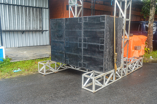 stack of six large sub woofer speakers arranged on top of iron sound rigging