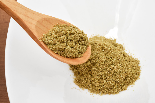 Fennel seed powder on a wooden spoon.