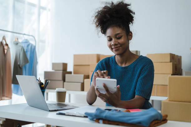 istock Entrepreneur using calculator in her hand, calculating financial expense at home office, online market packing box delivery,Startup successful small business owner, SME, concept. 1560114685