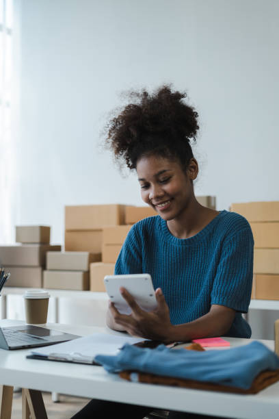 istock Entrepreneur using calculator in her hand, calculating financial expense at home office, online market packing box delivery,Startup successful small business owner, SME, concept. 1560115050