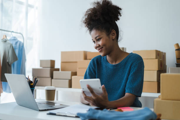 istock Entrepreneur using calculator in her hand, calculating financial expense at home office, online market packing box delivery,Startup successful small business owner, SME, concept. 1560115076