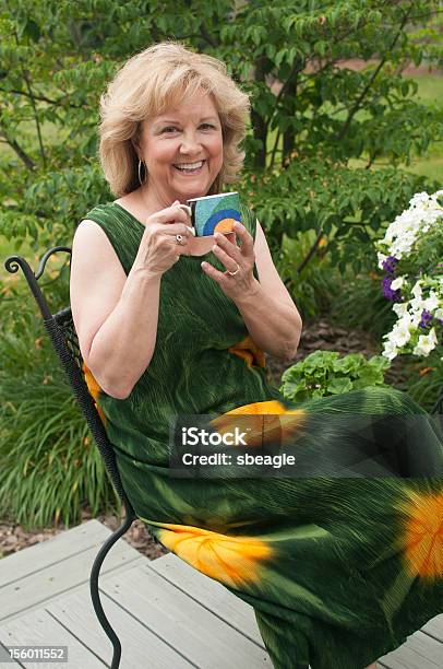 Cheerful Older Woman Holds A Coffee Mug Stock Photo - Download Image Now - 60-64 Years, One Person, Only Women