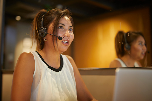istock Young lady helpdesk worker communicating with customer 1560126584