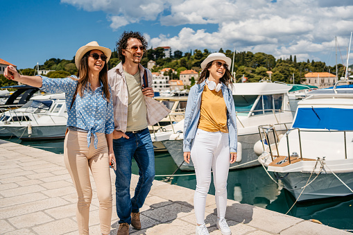 Three young tourists walking in Dubrovnik bay in Croatia.