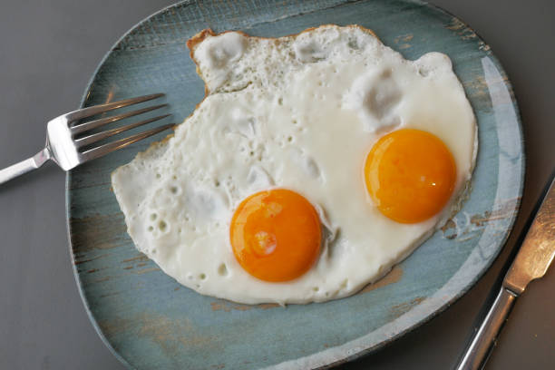 istock Fried eggs in the plate close up , 1560134695