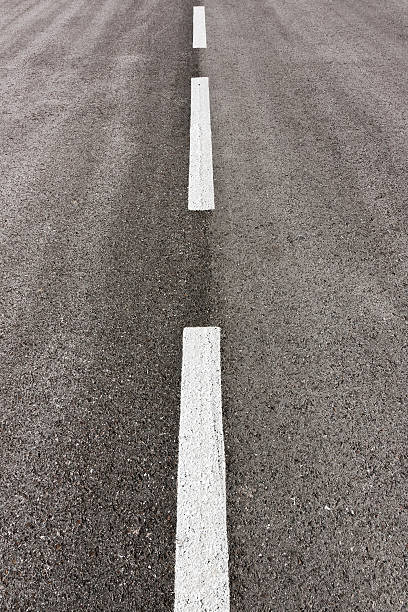 istock Vertical composition of tarmac road and white marks 156013563