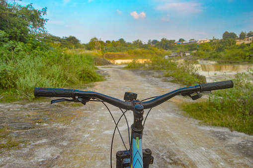you can see the handlebar of a pedal bike being ridden in a limestone quarry, Indonesia, 15 July 2023.