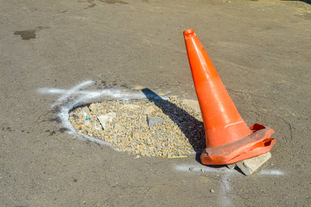 istock a traffic cone placed near a pothole as a sign 1560149366