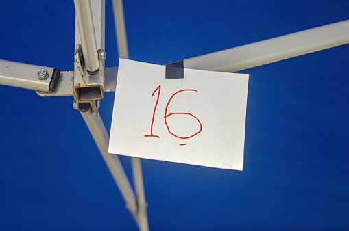 a piece of paper with the number 16 on it clamped on an iron