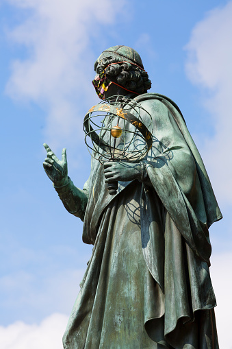 Torun, Poland - June 26, 2020: Nicolaus Copernicus Monument, statue of polish renaissance astronomer on the Old Town Square in front of the Town Hall. Sculpture with a protective mask, Covid-19 pandemic time