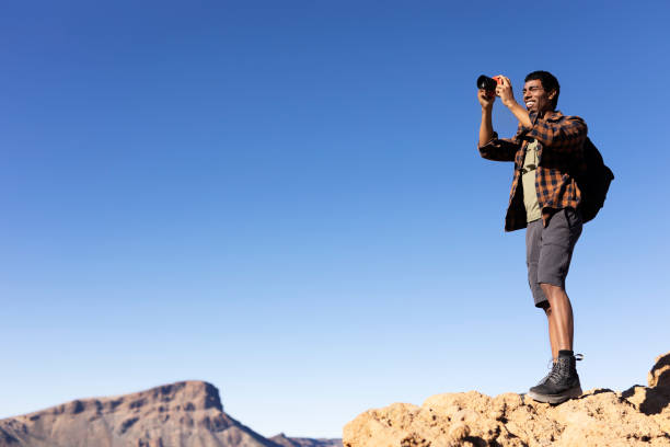istock Young man taking pictures on a road trip. 1560173422
