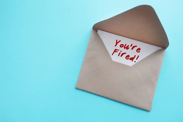 istock On blue copy space background, office envelope with handwritten card note YOU ARE FIRED!, means worker getting fired from position, boss or employer indicated employees they are discharged from job 1560175055