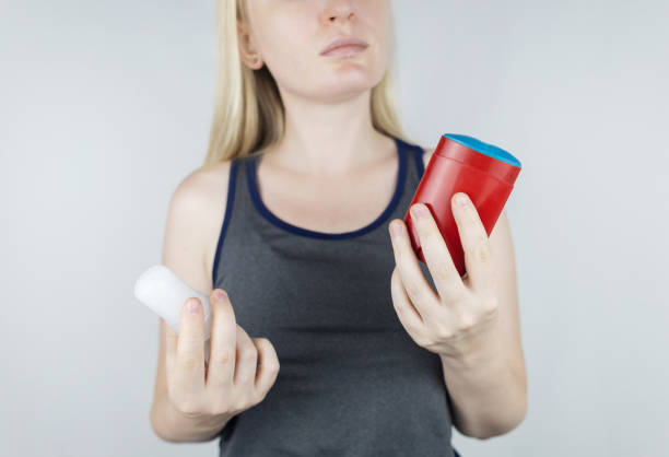 istock left or right. Girl chooses between eco-friendly deodorant without toxins and antiperspirant with toxic elements. In left hand Mineral alum crystal stick, in right hand classic remedy chemical nature 1560177875