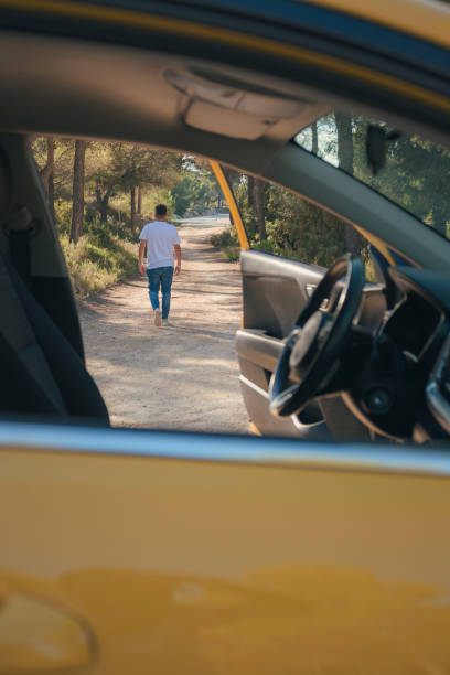 un homme latino sortant d’un véhicule sur une route forestière - leaving business landscape men photos et images de collection