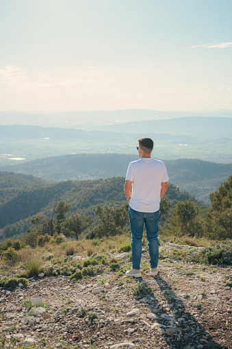 Man on the top of a mountain looking towards the horizon