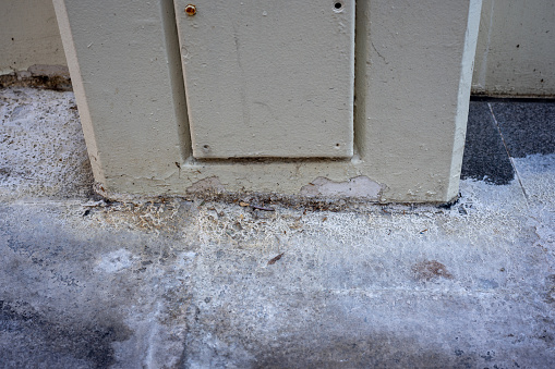 efflorescence, stain on the concrete stone floor white sediment formed on surfaces with component of cement, orange wall with craking leaking dirty stain