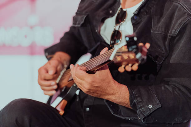 istock Practicing in playing guitar. Handsome young men playing guitar 1560184605
