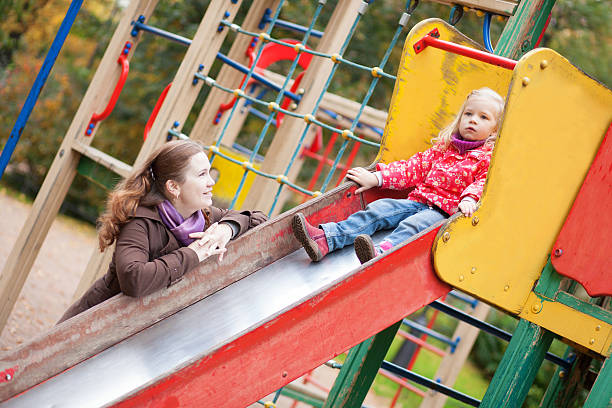 istock Mother looking at her daughter on slide 156018864