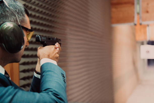 istock A man practices shooting a pistol in a shooting range while wearing protective headphones 1560197832