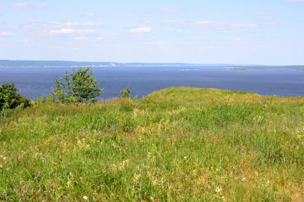istock green hill with grass and blue water on background horizon line and blue sky copy space 1560199961