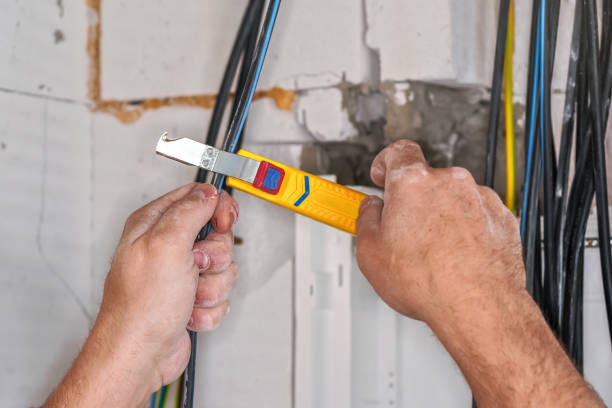 istock Electrician stripping insulation from power cables with wire stripper tool. Detail on his hands 1560214697