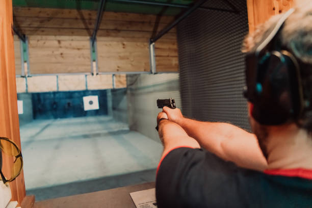 istock A man practices shooting a pistol in a shooting range while wearing protective headphones 1560221775