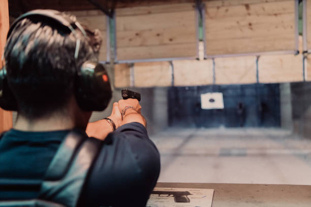 istock A man practices shooting a pistol in a shooting range while wearing protective headphones 1560222836