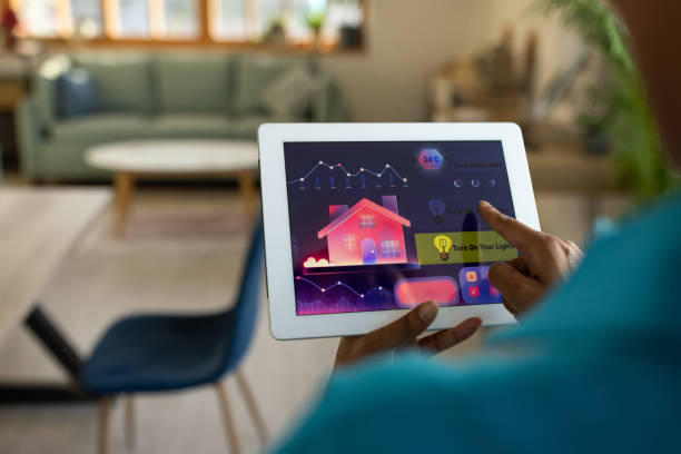 istock Woman using a tablet to control the lights in her apartment 1560222852