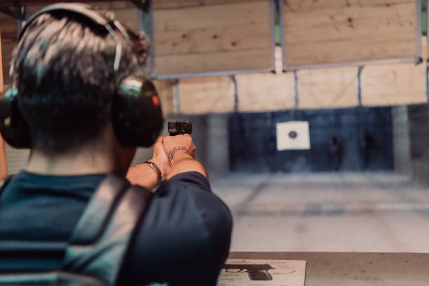 istock A man practices shooting a pistol in a shooting range while wearing protective headphones 1560225328