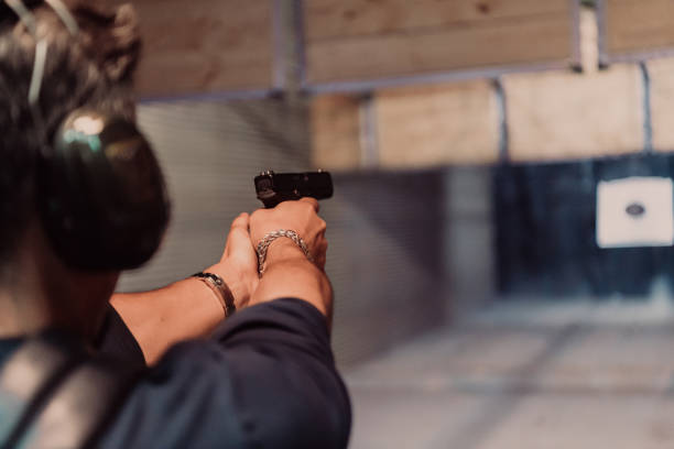 istock A man practices shooting a pistol in a shooting range while wearing protective headphones 1560226688