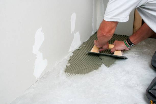 istock Bricklayer laying tiles on the floor 1560226714