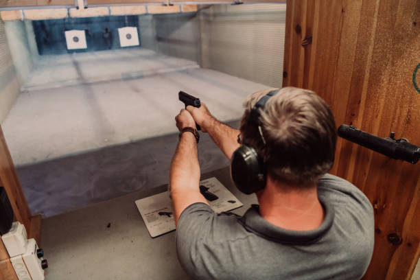 istock A man practices shooting a pistol in a shooting range while wearing protective headphones 1560227790