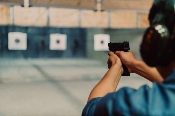 istock A man practices shooting a pistol in a shooting range while wearing protective headphones 1560228913