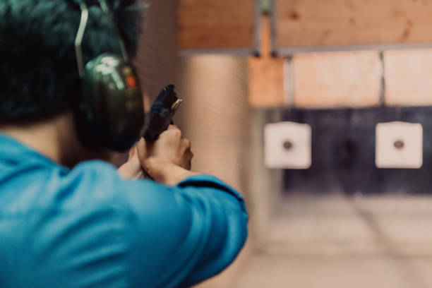 istock A man practices shooting a pistol in a shooting range while wearing protective headphones 1560232106