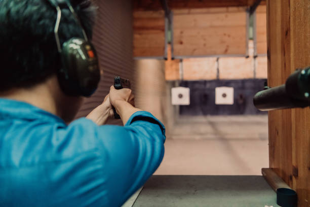 istock A man practices shooting a pistol in a shooting range while wearing protective headphones 1560233238